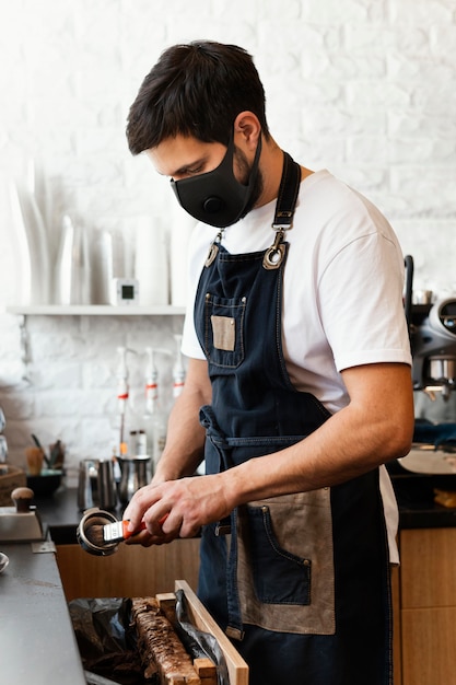 Bezpłatne zdjęcie Średni strzał barista przygotowujący kawę