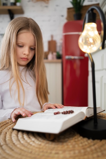 Średni strzał dziewczynka czytająca Biblię