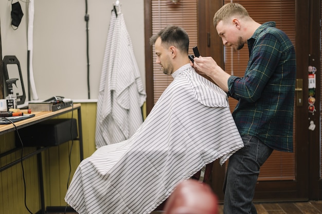 Bezpłatne zdjęcie Średni strzał hairstilyst daje fryzurę