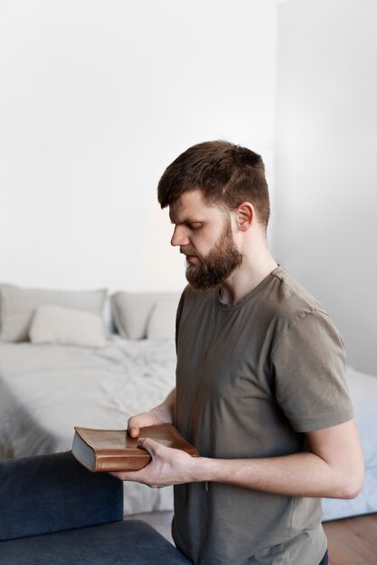 Średni strzał młody mężczyzna trzymający Biblię