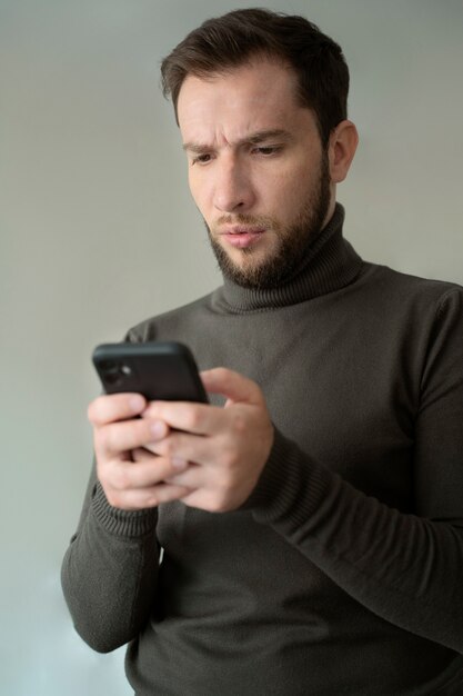 Średni strzał niespokojny mężczyzna trzymający smartfon