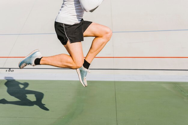 Średni strzał sportowca skaczącego podczas treningu