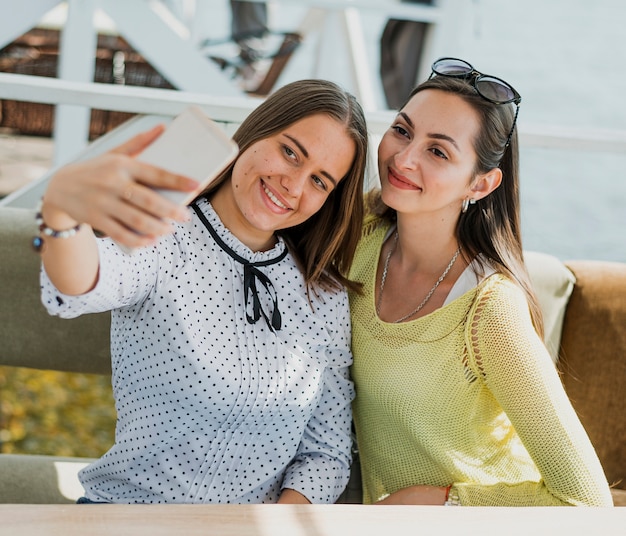 Średni strzał szczęśliwych przyjaciół przy selfie