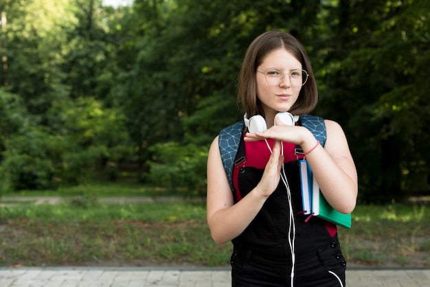 Bezpłatne zdjęcie Średni strzał z highschool girl gospodarstwa timeout znak