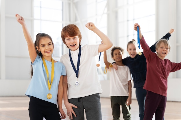 Średnie strzały podekscytowane dzieci z medalami