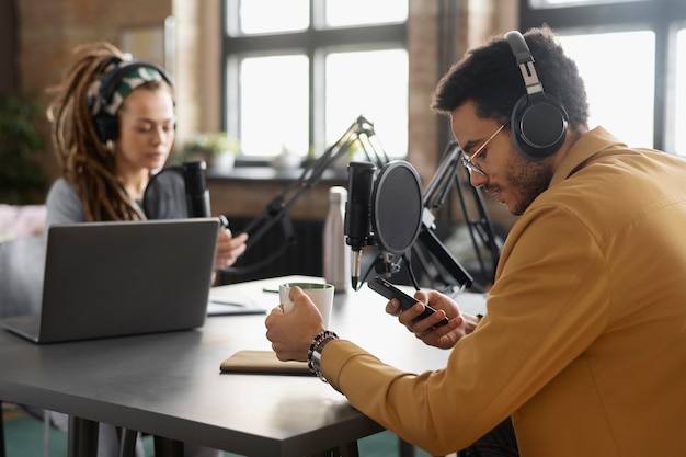 Średnie ujęcie młodych ludzi nagrywających podcast
