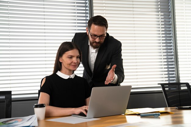 Średnie ujęcie osób pracujących z laptopem