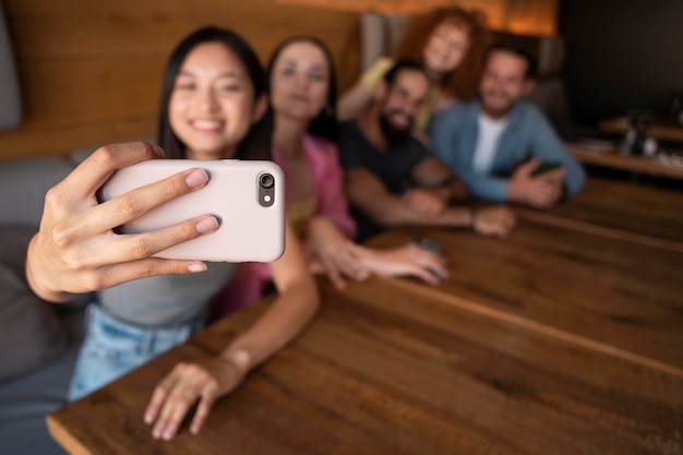 Bezpłatne zdjęcie Średnie ujęcie, rozmazani przyjaciele robiący selfie