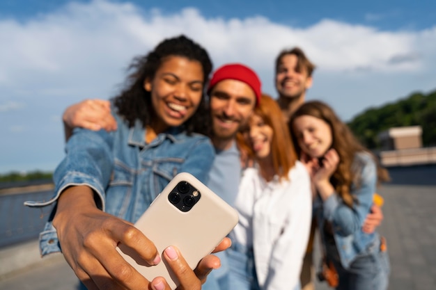 Średnie zdjęcie przyjaciół robiących wspólne selfie.