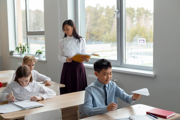 Średnio strzał chłopiec z adhd robi papierowy samolot