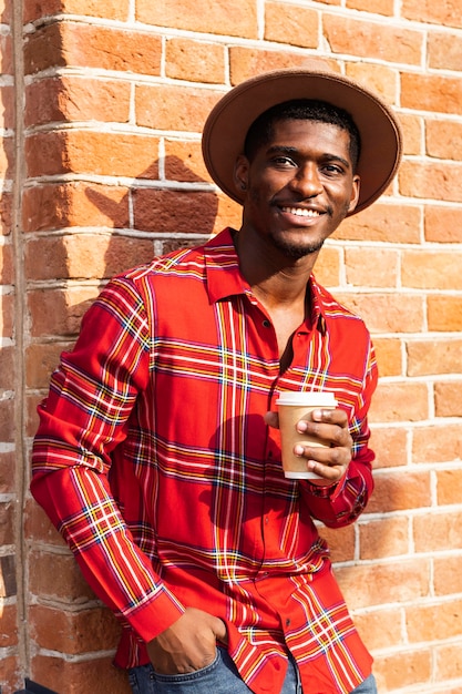 Bezpłatne zdjęcie Średnio strzał człowieka w czerwonej koszuli picia kawy