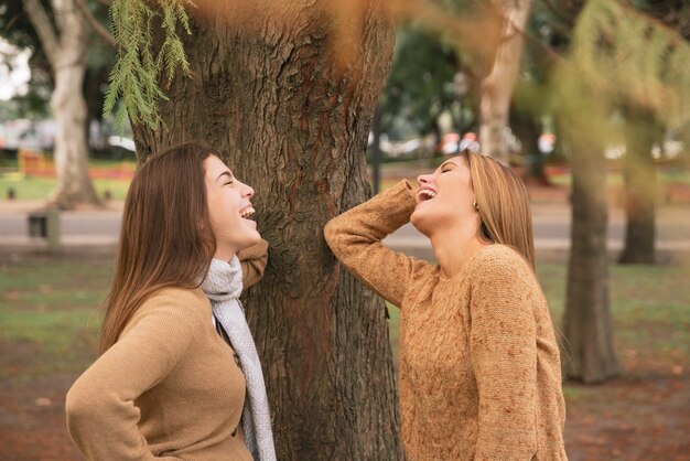 Średnio strzał dwóch kobiet śmieje się w parku