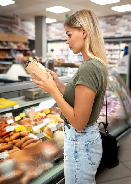 Średnio strzał kobieta czyta etykietę produktu