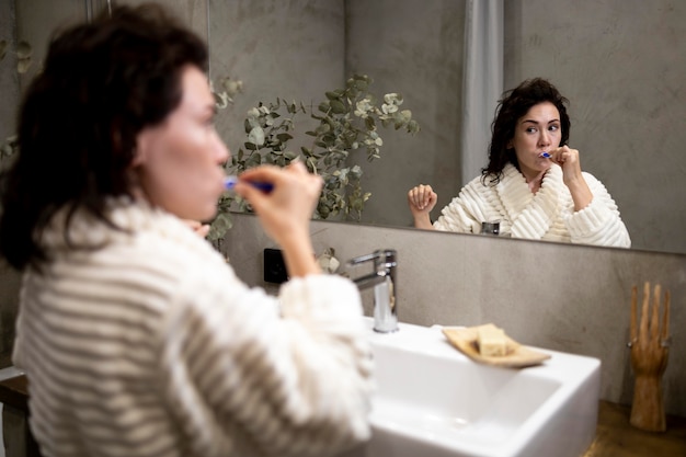 Bezpłatne zdjęcie Średnio strzał kobieta myjąca zęby