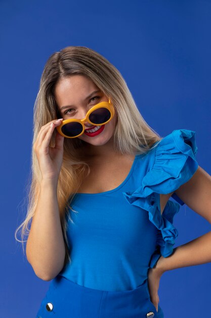 Średnio strzał kobieta pozuje w okularach przeciwsłonecznych