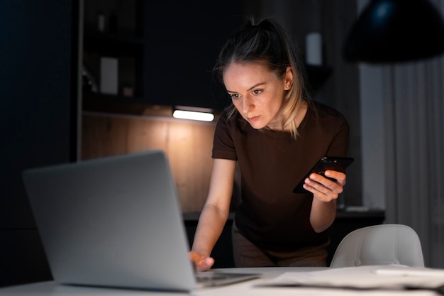 Bezpłatne zdjęcie Średnio strzał kobieta pracująca na laptopie