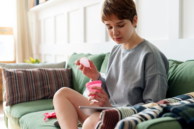 Średnio strzał kobieta trzymająca kubek menstruacyjny