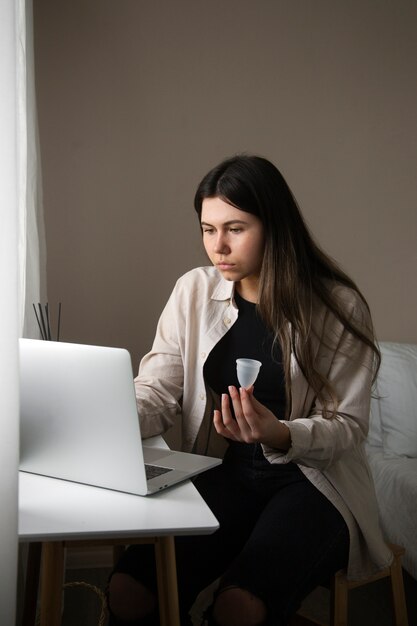 Bezpłatne zdjęcie Średnio strzał kobieta trzymająca kubek menstruacyjny