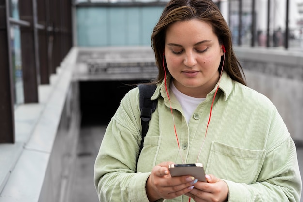 Bezpłatne zdjęcie Średnio strzał kobieta trzymająca telefon