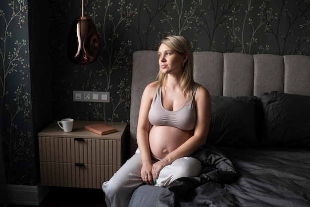 Średnio strzał kobieta w ciąży na łóżku