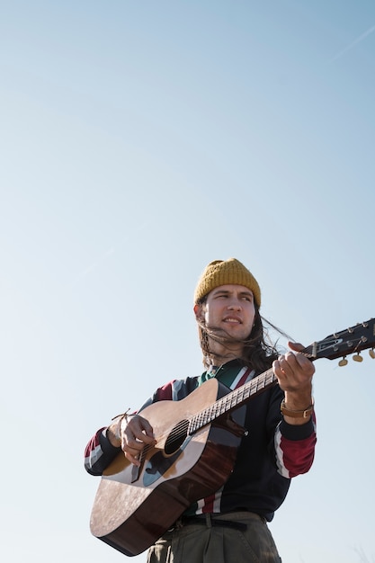 Średnio Strzał Mężczyzna Grający Na Gitarze