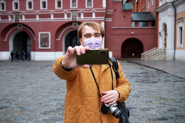 Średnio strzał mężczyzna z maską na twarz robi selfie