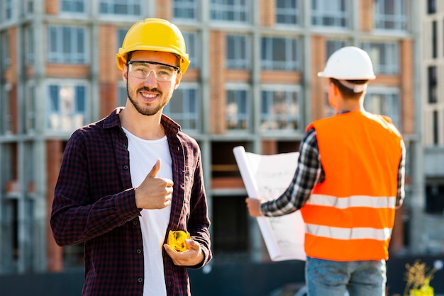 Bezpłatne zdjęcie Średnio strzał portret uśmiechniętego architekta patrząc na kamery