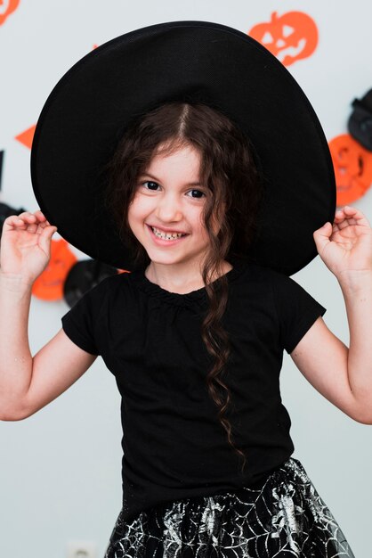 Średnio strzał śliczna mała dziewczynka z czarownica kapeluszem