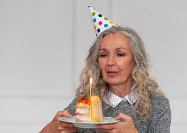 Średnio strzał stara kobieta trzyma tort