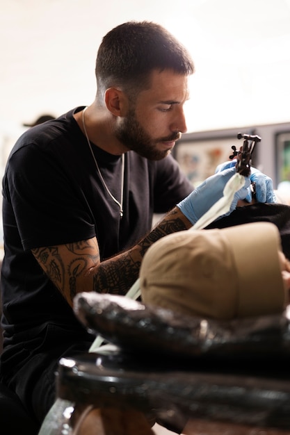 Bezpłatne zdjęcie Średnio strzał tatuażysta wykonujący swoją pracę
