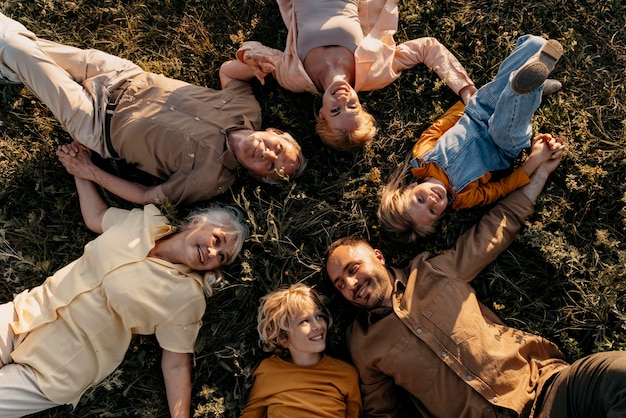 Bezpłatne zdjęcie Średnio strzał uśmiechnięci ludzie leżący na trawie