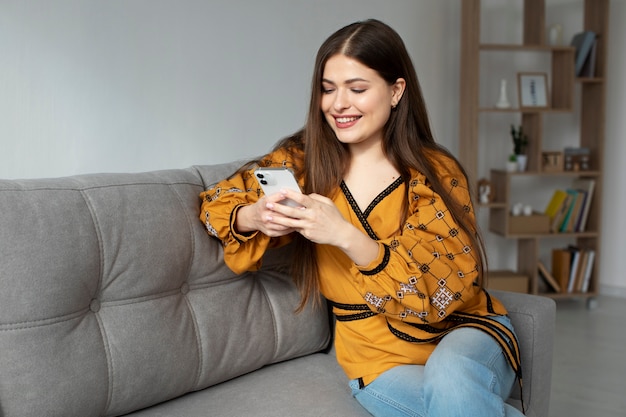 Bezpłatne zdjęcie Średnio strzał uśmiechnięta kobieta trzymająca telefon