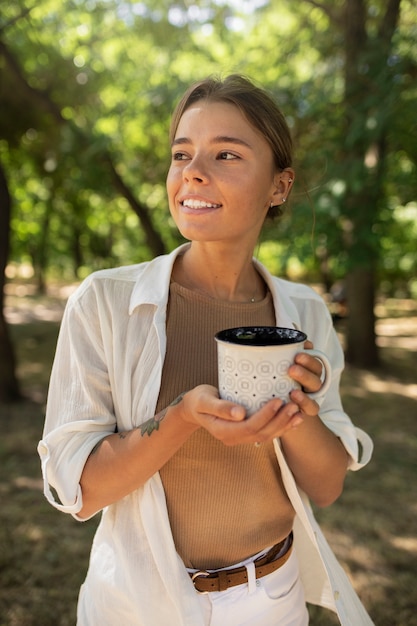 Bezpłatne zdjęcie Średnio strzał uśmiechnięta kobieta z filiżanką kawy