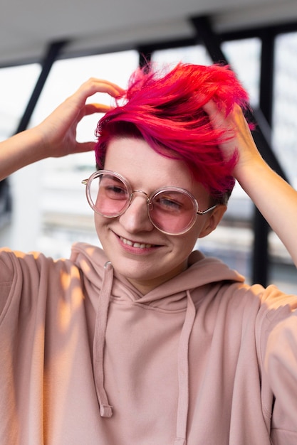 Bezpłatne zdjęcie Średnio strzał uśmiechnięta nastolatka z różowymi włosami