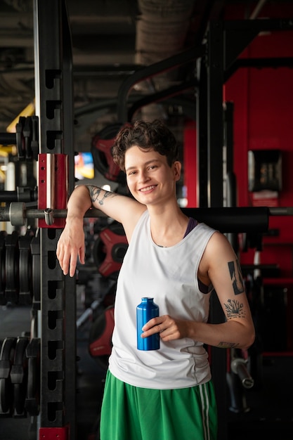 Bezpłatne zdjęcie Średnio strzał uśmiechnięta osoba trans na siłowni