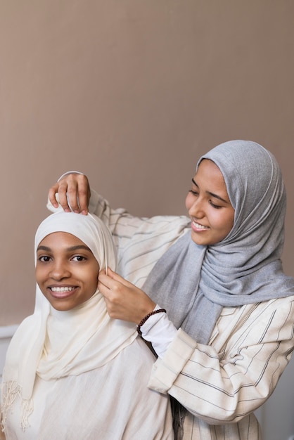 Średnio strzał uśmiechnięte kobiety noszące hidżab