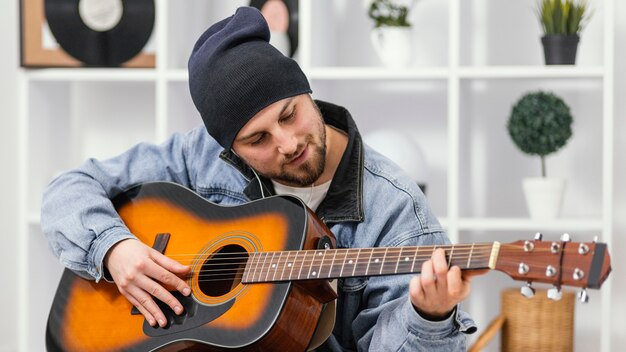 Średnio strzał uśmiechnięty mężczyzna gra na gitarze