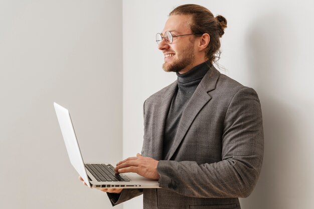 Średnio strzał uśmiechnięty mężczyzna trzymający laptopa