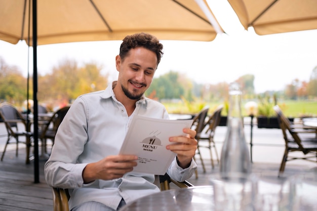 Średnio strzałowy mężczyzna czytający menu