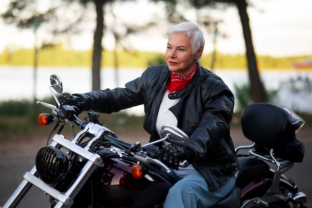 Bezpłatne zdjęcie Średnio strzelająca starsza kobieta na motocyklu