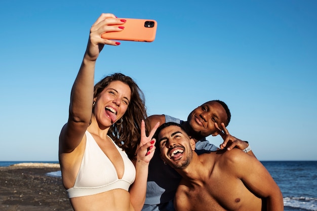 Średnio ujęcia uśmiechnięci ludzie przy selfie