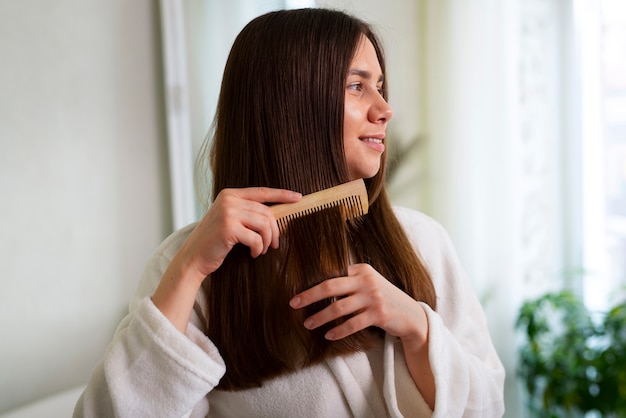 Średnio ujęcie kobiety, która macha włosami podczas wieczornej rutyny