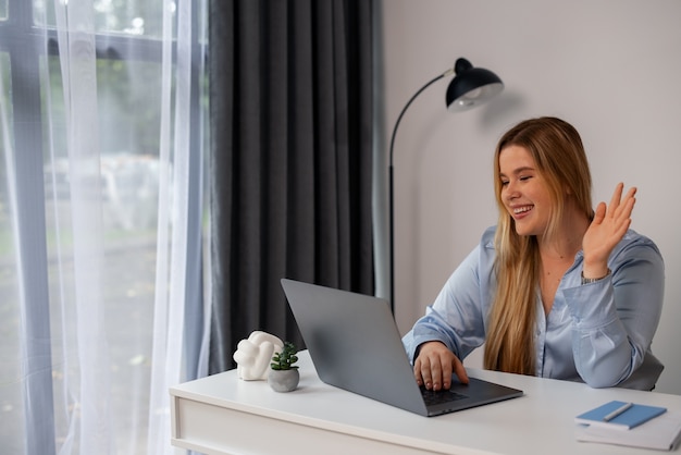 Bezpłatne zdjęcie Średnio ujęcie kobiety prowadzącej rozmowy wideo z laptopem
