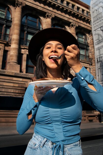 Średnio ujęcie meksykańskiej kobiety jedzącej jedzenie Ranchero