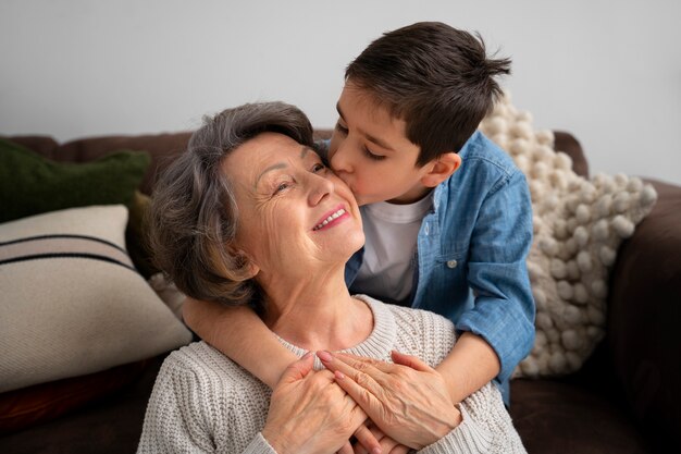 Średnio ujęcie wnuka całującego babcię