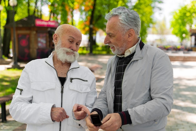 Średnio ustrzeleni mężczyźni z telefonem na zewnątrz