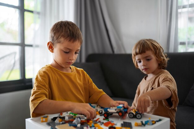 Średnio ustrzelone dzieci bawiące się zabawkami w pomieszczeniu