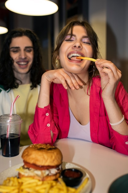 Średnio zastrzeleni przyjaciele jedzący fast foody w zabawny sposób