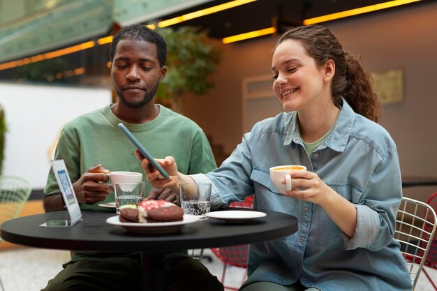 Średnio zastrzeleni uśmiechnięci ludzie w restauracji