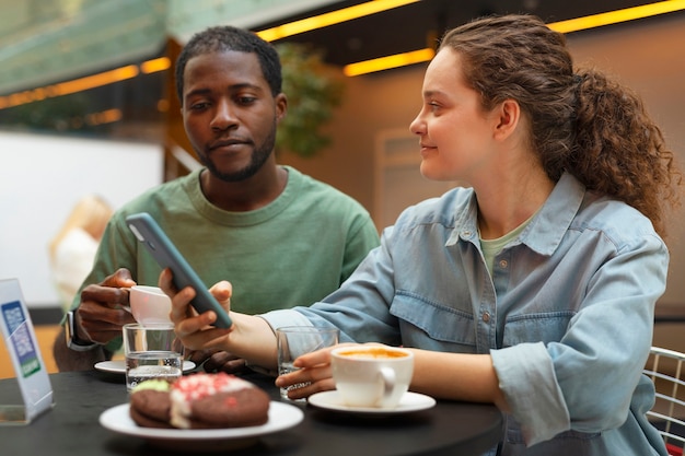 Średnio zastrzeleni uśmiechnięci ludzie w restauracji